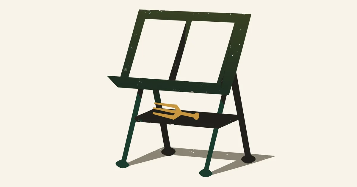Folding music stand holding blank sheet music with a gold tuning fork on the tray